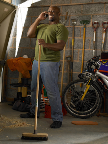 Man on mobile sweeping garage